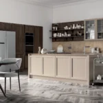 Una cucina in stile classico realizzata in legno con isola centrale, caratterizzata da dettagli artigianali e finiture eleganti.